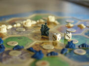 Board Games Market Set to Hit $3.2B in 2026 A board game in progress with a miniature, dice and hexagon playing field.