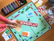 95% of All Americans Play Board Games Today Two people playing Monopoly board game.