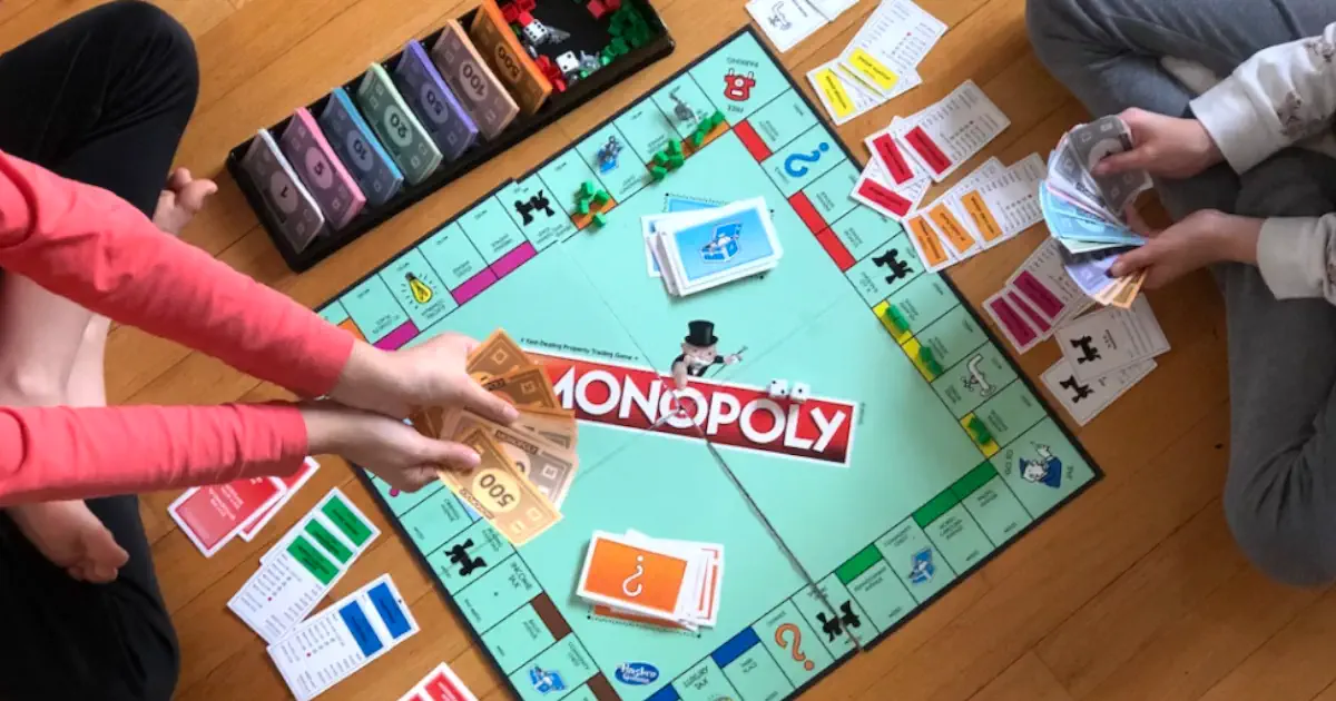 Two people playing Monopoly board game.