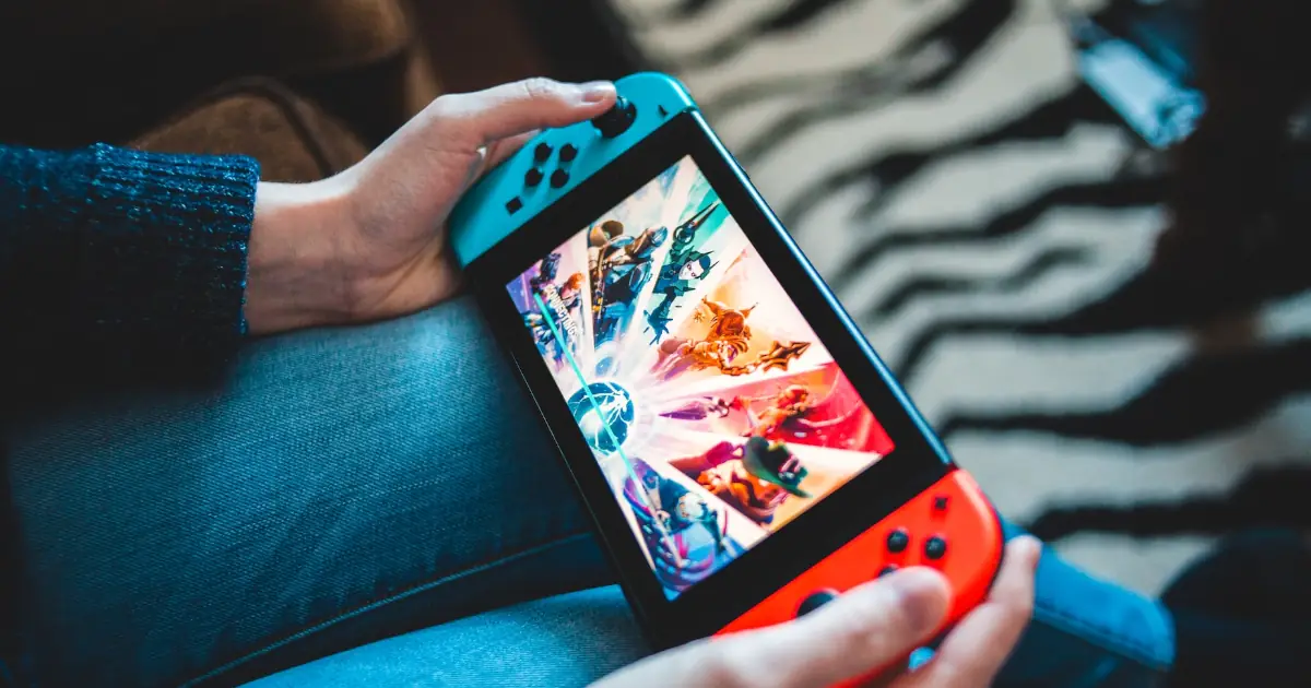 A person holding and playing at a Nintendo Switch.